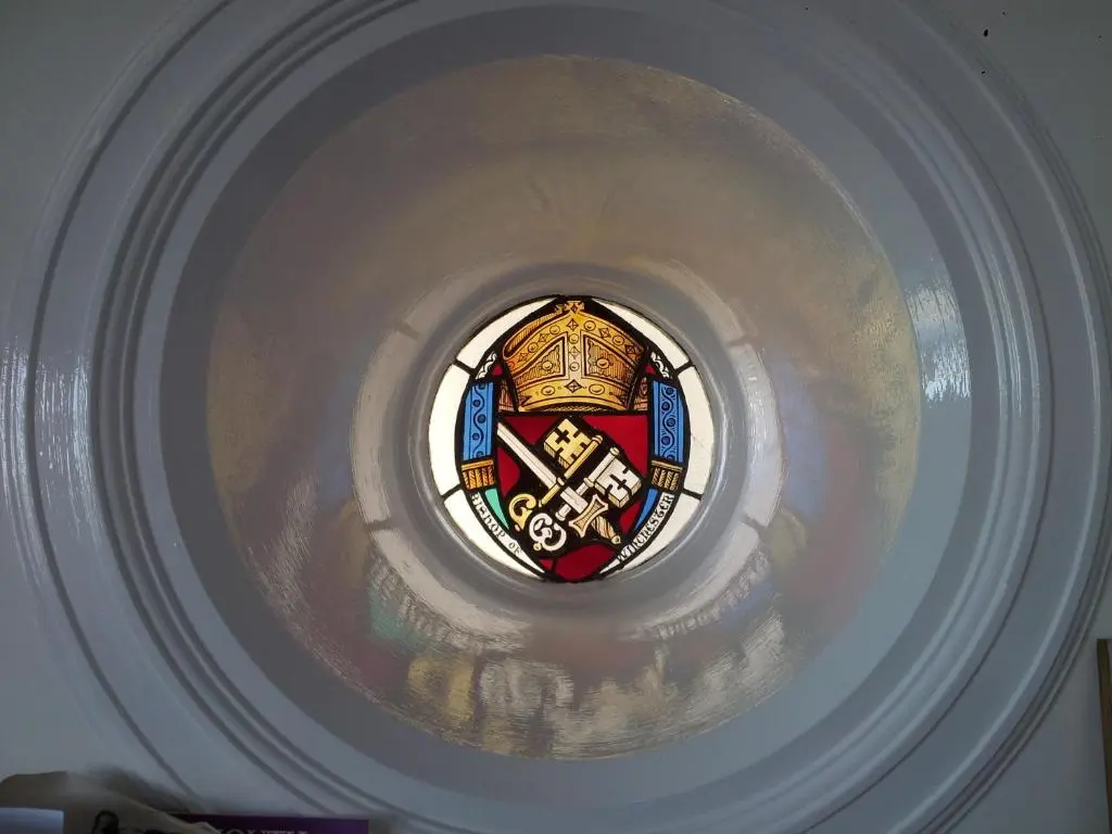 a round window in a stairwell with a stained glass at Links Lodge in Lossiemouth