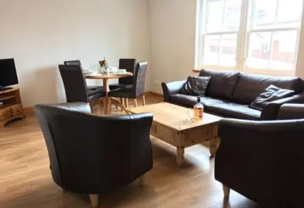 a living room with a couch and chairs and a table at Morris Gardens Apartments in Oldmeldrum