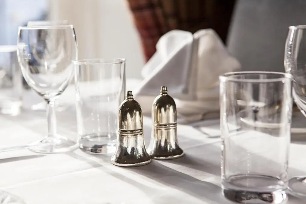 a table with wine glasses and two salt and pepper shakers at Burnett Arms Hotel in Banchory