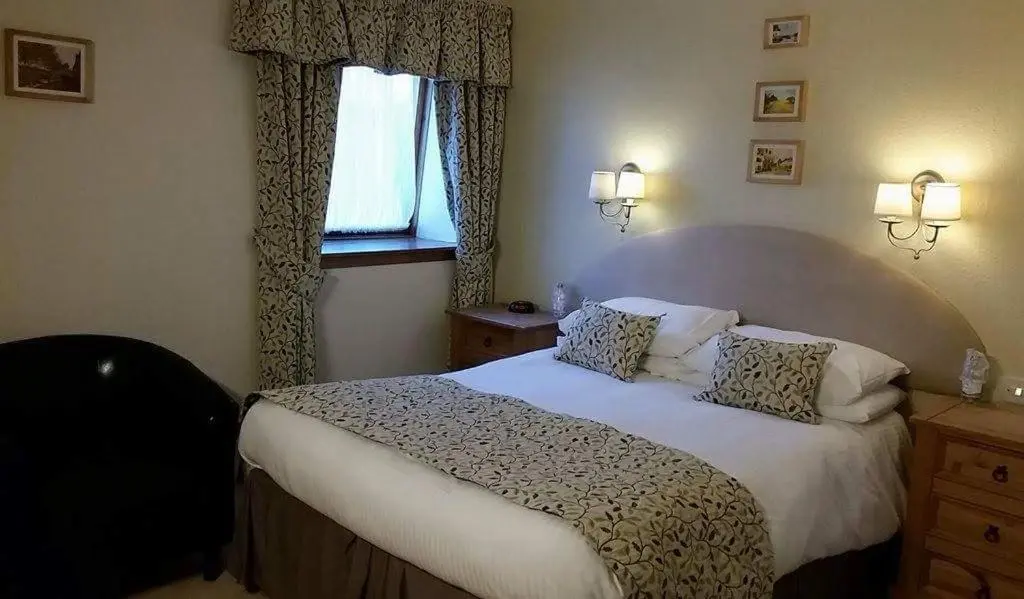 a bedroom with a bed and a window at The Royal Hotel Tain in Tain