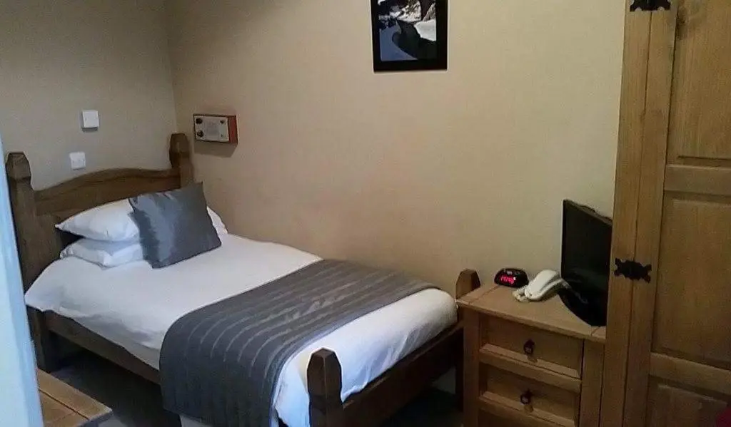 a bedroom with a bed and a phone and a television at The Royal Hotel Tain in Tain