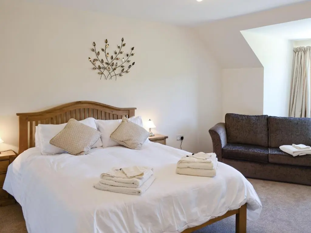 a bedroom with a bed with towels on it at March Cottage in Glenrossal