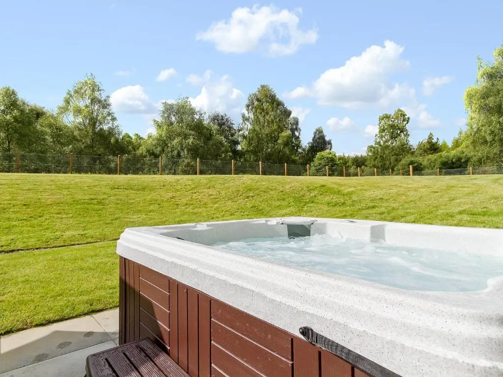 a hot tub in the middle of a field at Birch Corner in Aviemore