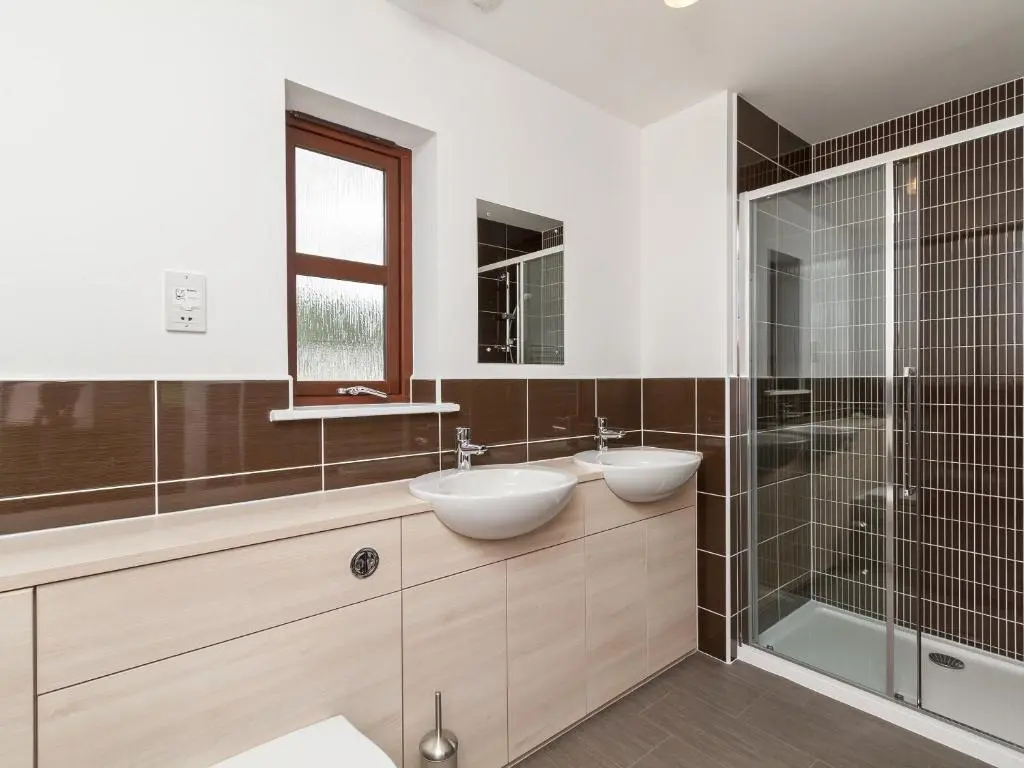 a bathroom with two sinks and a glass shower at Birch Corner in Aviemore