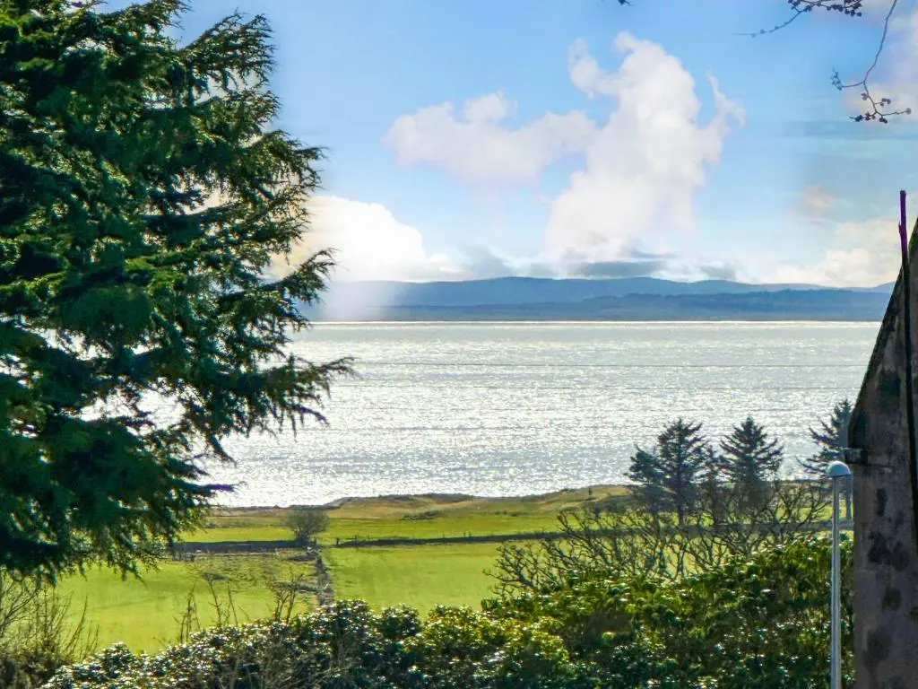 a view of a lake with a rainbow in the distance at Drummuie House in Golspie
