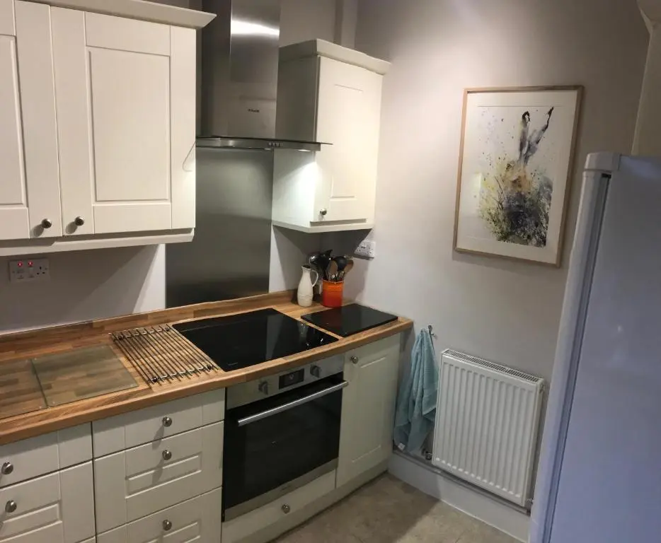 a kitchen with a sink and a stove top oven at Carrick House in Kingussie