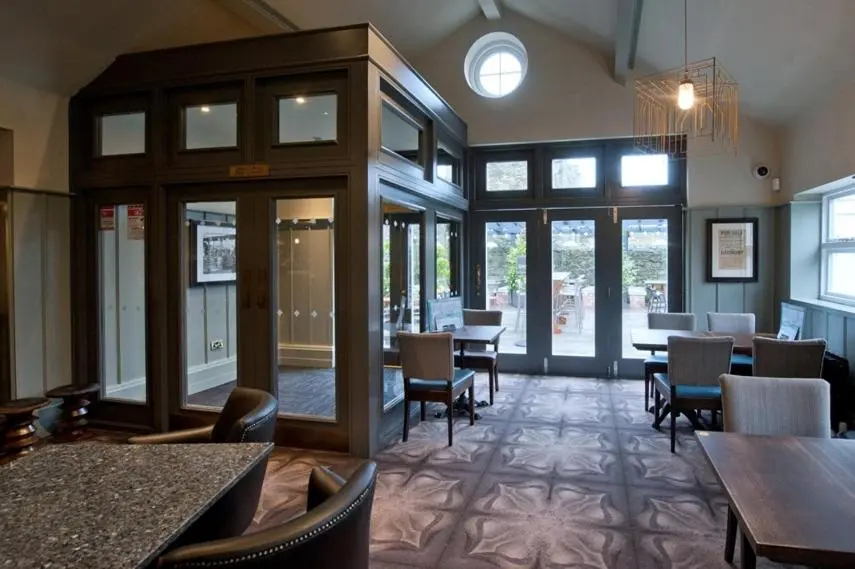 a dining room with tables and chairs and windows at The Saltoun Inn in Fraserburgh