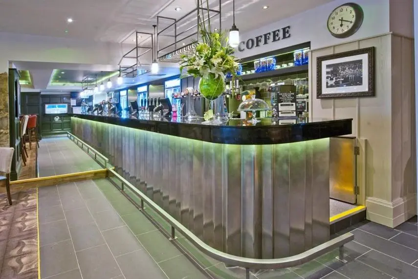 a bar in a restaurant with a clock on the wall at The Saltoun Inn in Fraserburgh