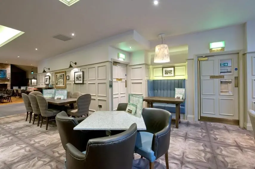a waiting room with tables and chairs in a building at The Saltoun Inn in Fraserburgh