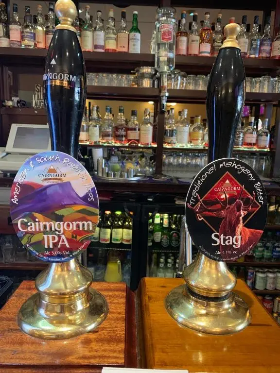 two bottles of beer sitting on top of a bar at Alexandra Hotel in Ballater