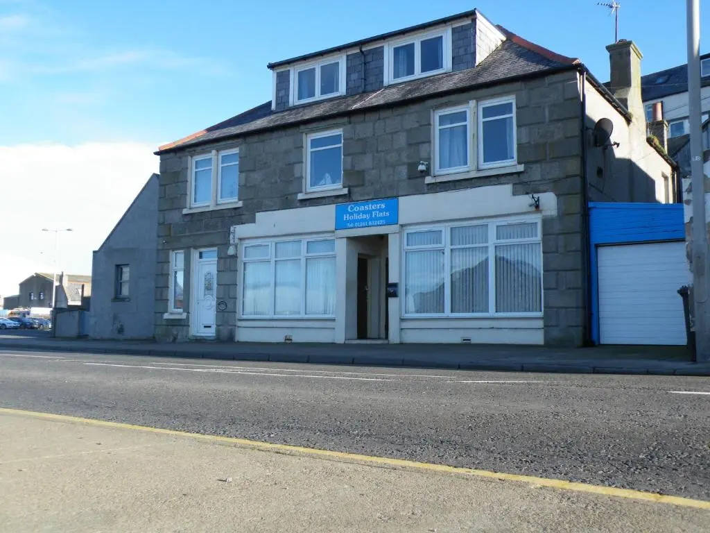 a brick building on the side of a street at Coasters Holiday Flats in Macduff
