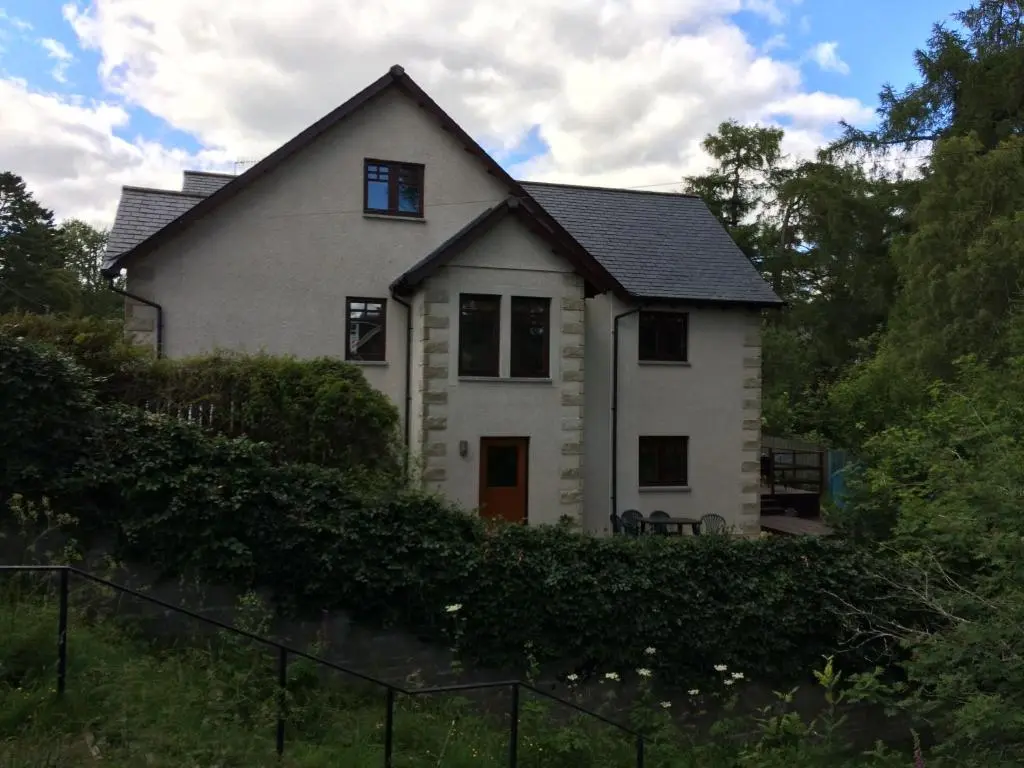 a white house with a black roof at Dullatur in Newtonmore