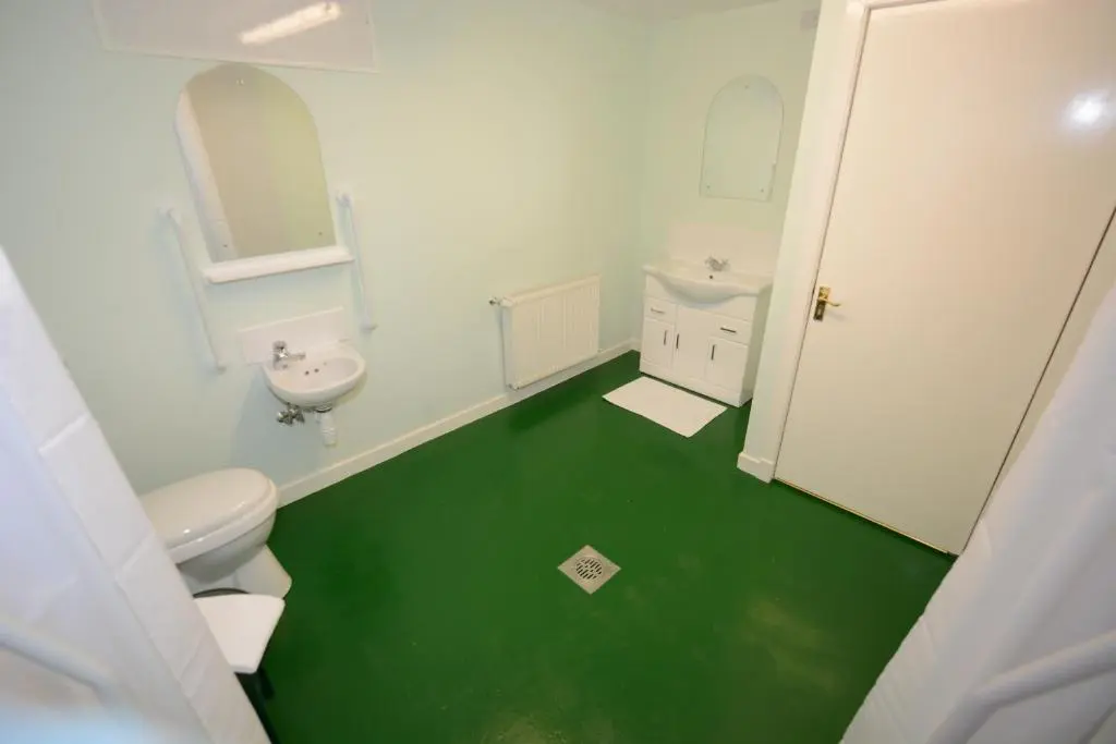 a bathroom with a white toilet and a green floor at Elgin City Centre Torr House hotel in Elgin