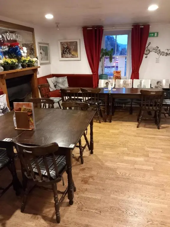 a dining room with wooden tables and chairs at Aberdeen Arms Hotel Tarland in Tarland
