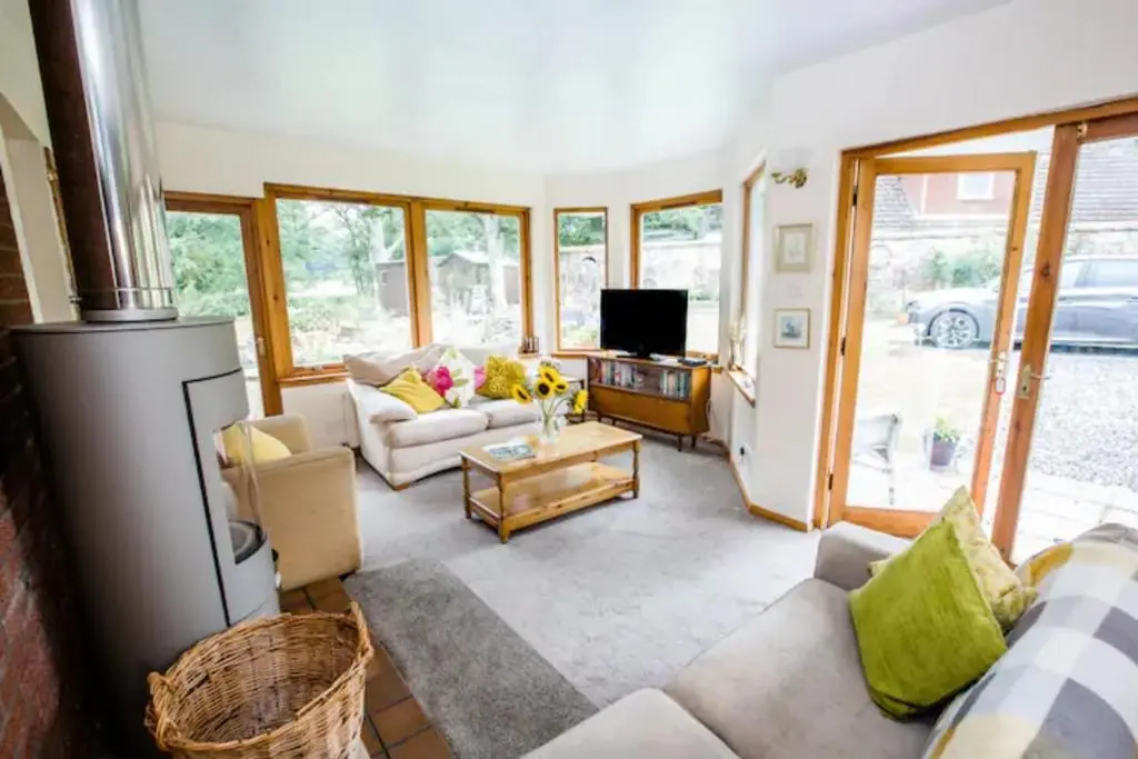 a living room with a couch and a tv at Home Comforts in Peaceful 2 Acres in Inverness
