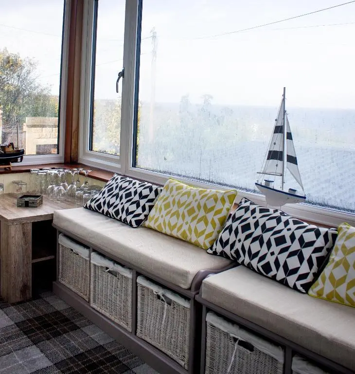 a couch in a room with a sailboat in the window at Kintrae B&B in Buckie