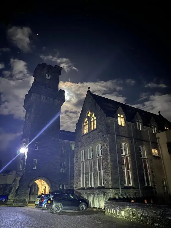 a building with a car parked in front of it at night at The Classrooms, Loch Ness Abbey - 142m2 Lifestyle & Heritage apartment - Pool & Spa - The Highland Club - Resort on lake shores in Fort Augustus