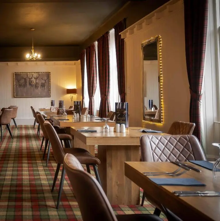 a waiting room with tables and chairs and a mirror at The Balavil Hotel Newtonmore - Restaurant, Bars & Swimming Pool in Newtonmore