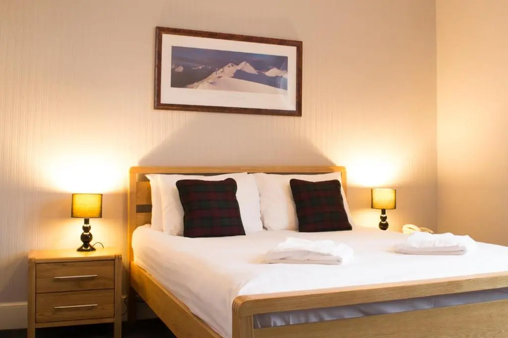 a bedroom with a large bed with two lamps at The Balavil Hotel Newtonmore - Restaurant, Bars & Swimming Pool in Newtonmore