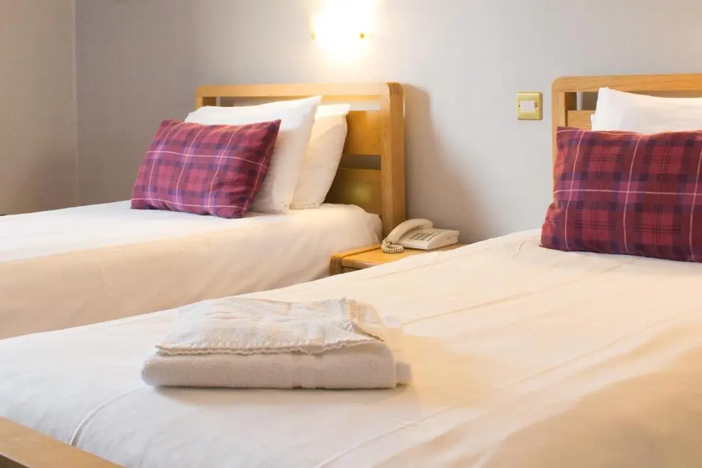 a hotel room with two beds and a phone at The Balavil Hotel Newtonmore - Restaurant, Bars & Swimming Pool in Newtonmore