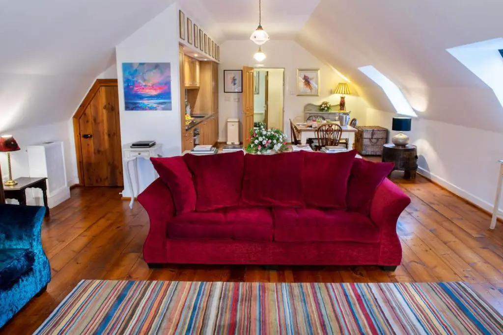 a red couch in the middle of a living room at Boys Dormitory in Fort Augustus