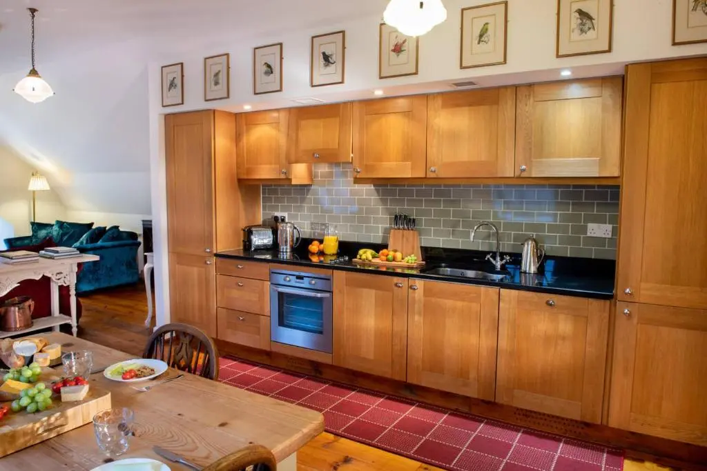 a kitchen with wooden cabinets and a wooden table at Boys Dormitory in Fort Augustus