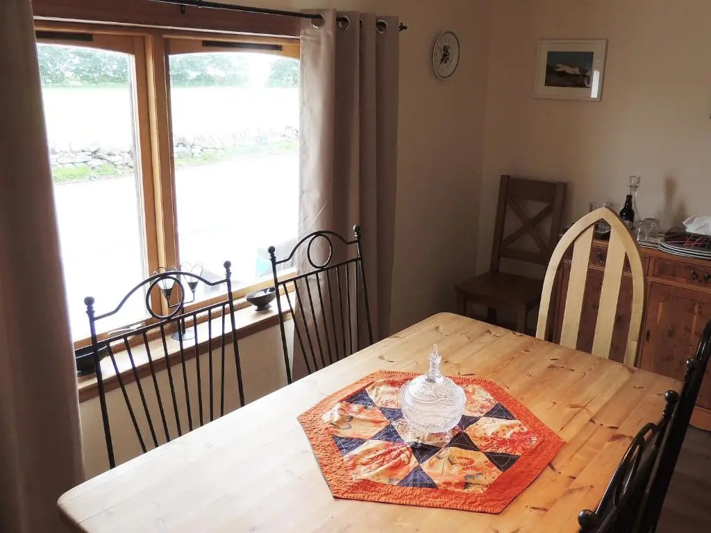 a wooden table with a plate on top of it at Invicta House B&B in Golspie