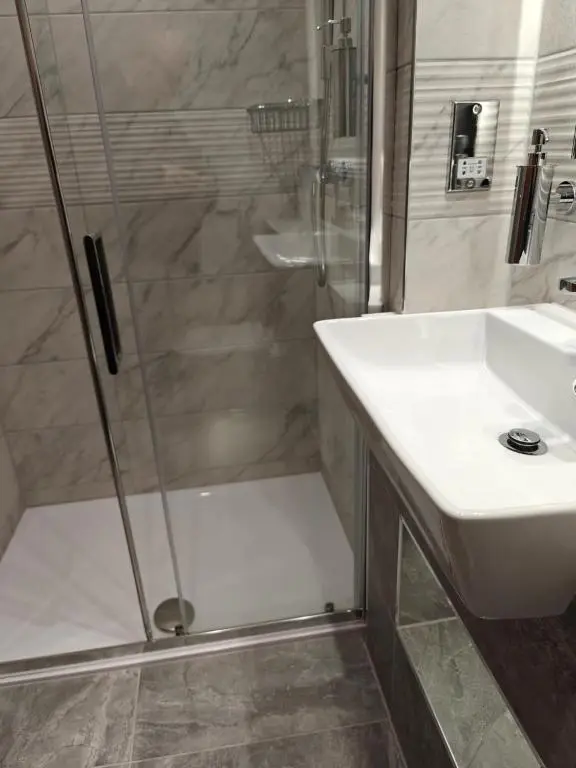 a bathroom with a shower and a sink at Beaufort Hotel in Inverness
