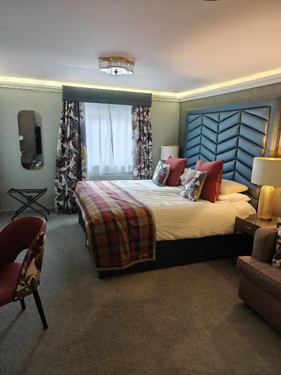 a bedroom with a large bed and a television at Beaufort Hotel in Inverness