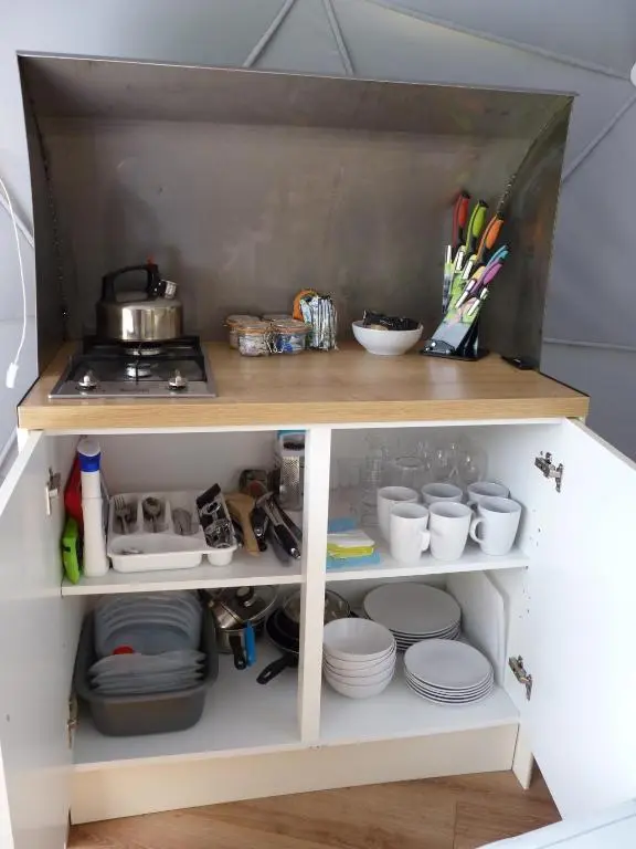 a kitchen shelf with plates and utensils at Inver Coille Campsite in Fort Augustus