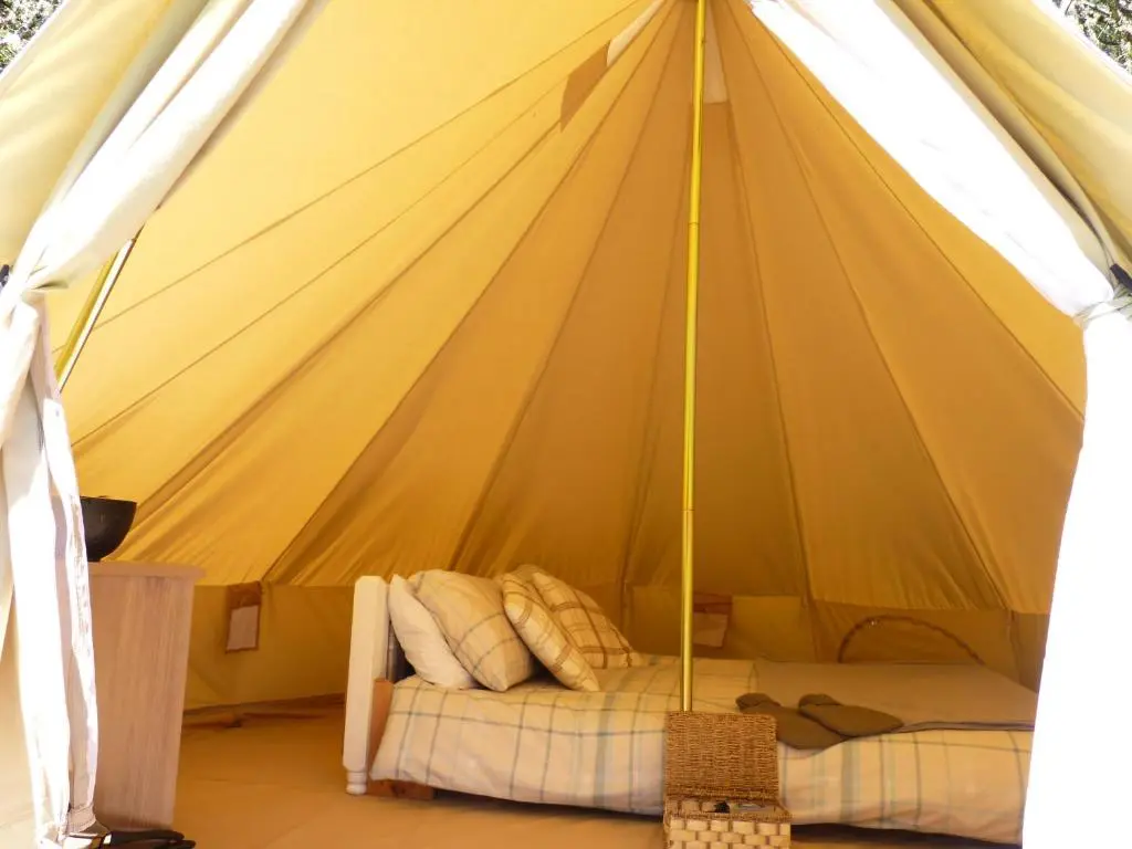 a yellow tent with a bed in it at Inver Coille Campsite in Fort Augustus