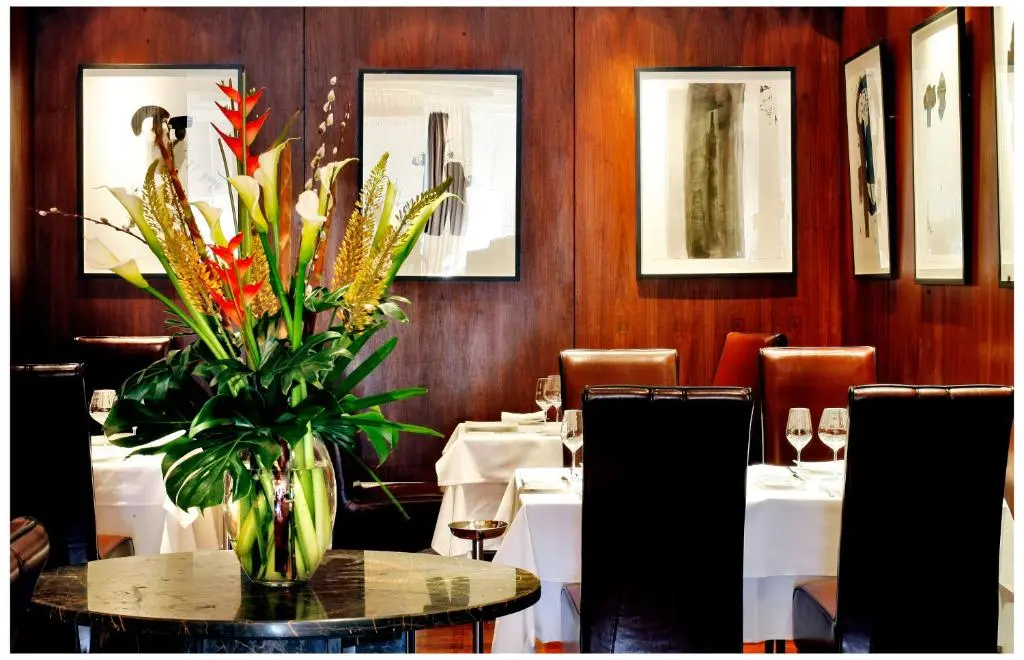 a dining room with a table with a vase of flowers at Glenmoriston Town House Apartments in Inverness