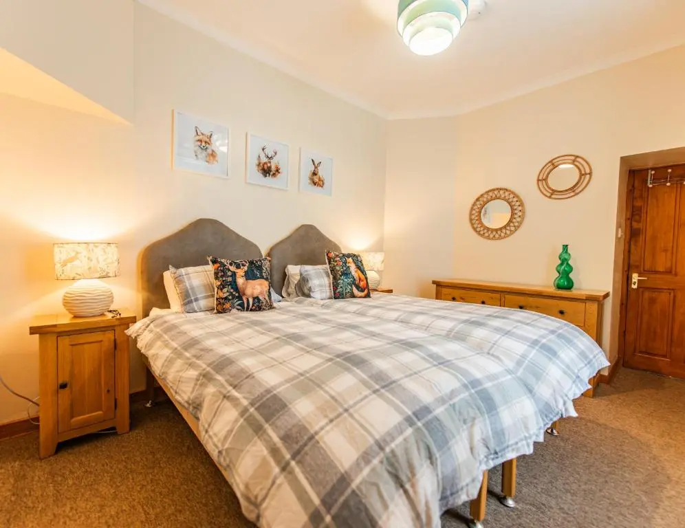 a bedroom with a bed and two night stands at Elgin Self Catering Holiday Cottage in Elgin