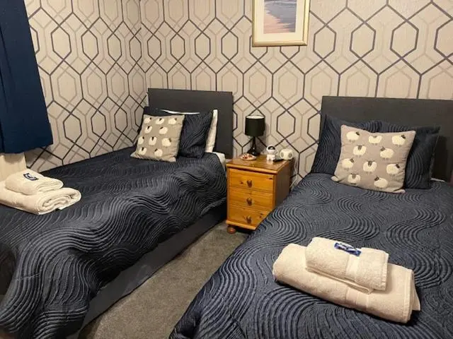 two beds sitting next to each other in a bedroom at Dionard Guest House in Inverness