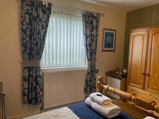 a bedroom with a bed with towels on it at Dionard Guest House in Inverness