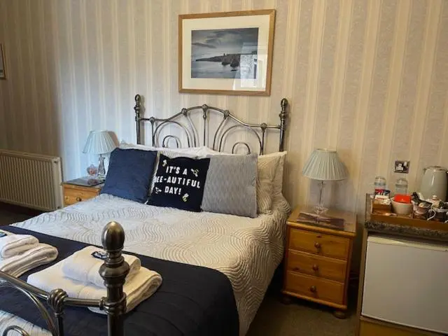 a bedroom with a bed with a pillow on it at Dionard Guest House in Inverness