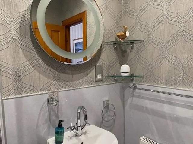 a bathroom with a sink and a mirror at Dionard Guest House in Inverness