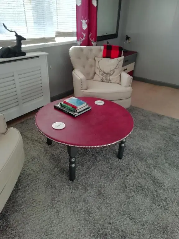 a living room with a red coffee table and a chair at Argyle Guest House in Tomintoul