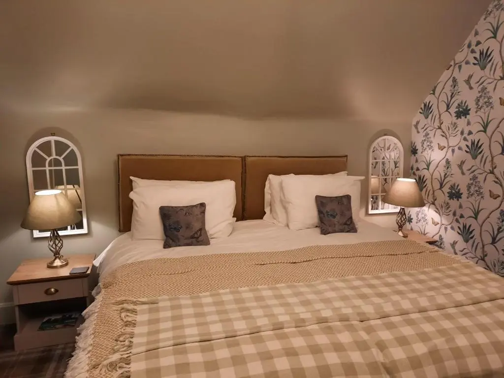 a bedroom with a bed with two pillows and two lamps at Argyle Guest House in Tomintoul