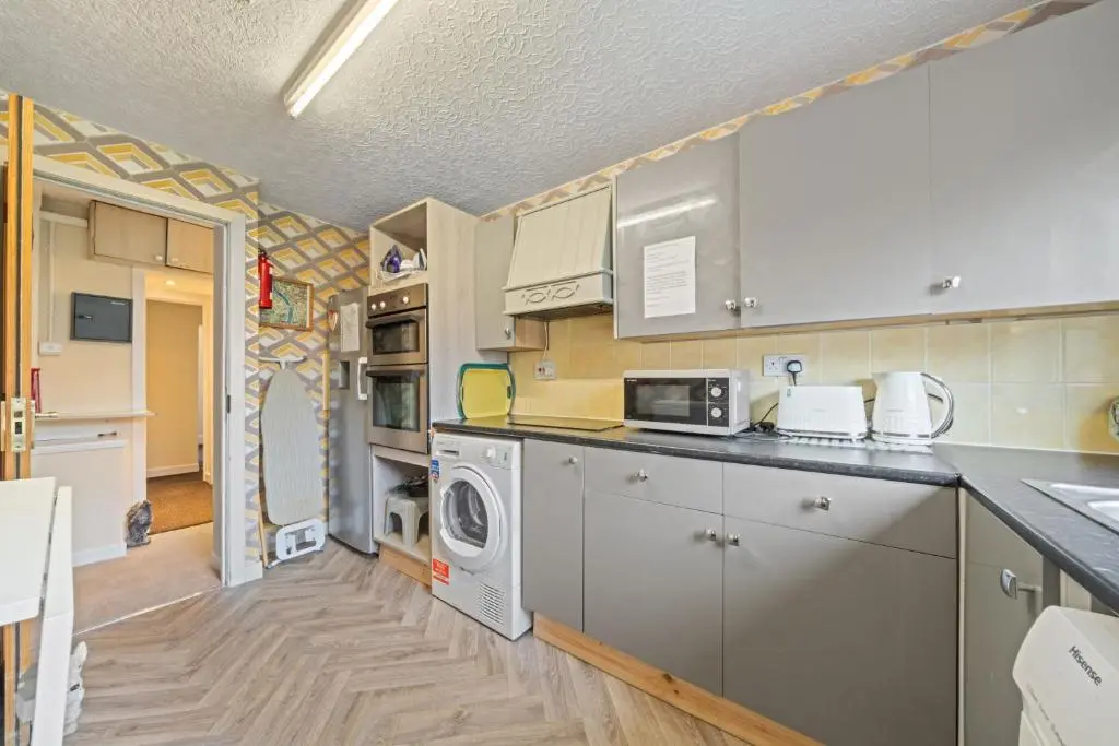 a kitchen with a washer and dryer at mySTAYINN Strathblane House in Inverness
