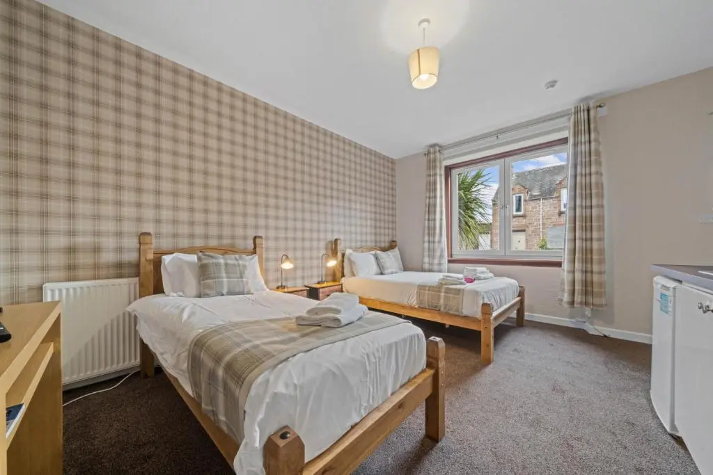 a bedroom with two beds and a window at mySTAYINN Strathblane House in Inverness