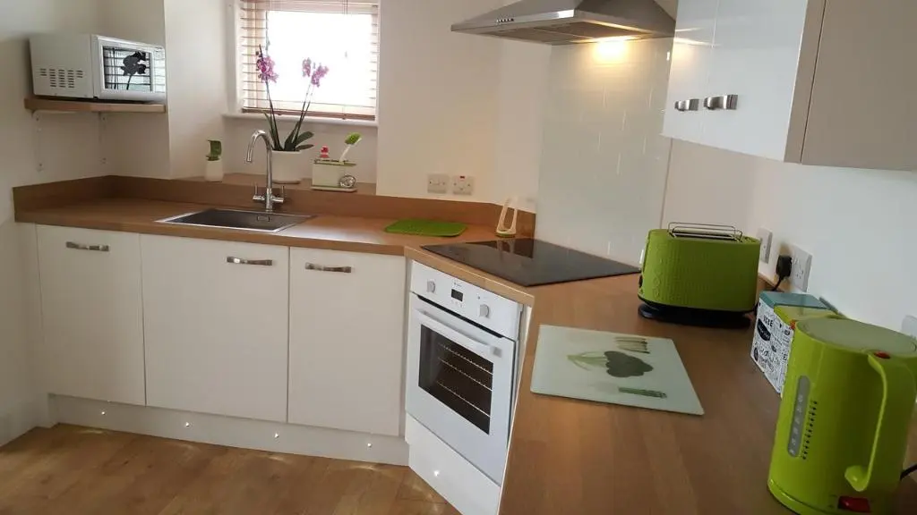 a kitchen with white cabinets and a green appliance at Tighnabruaich Annex in Lossiemouth