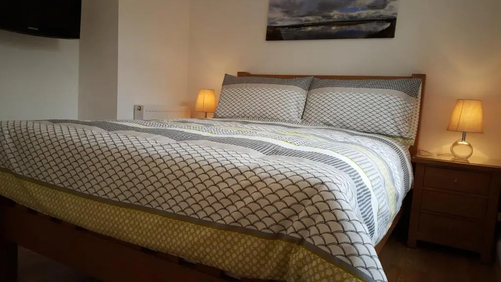 a bedroom with a large bed with two lamps at Tighnabruaich Annex in Lossiemouth