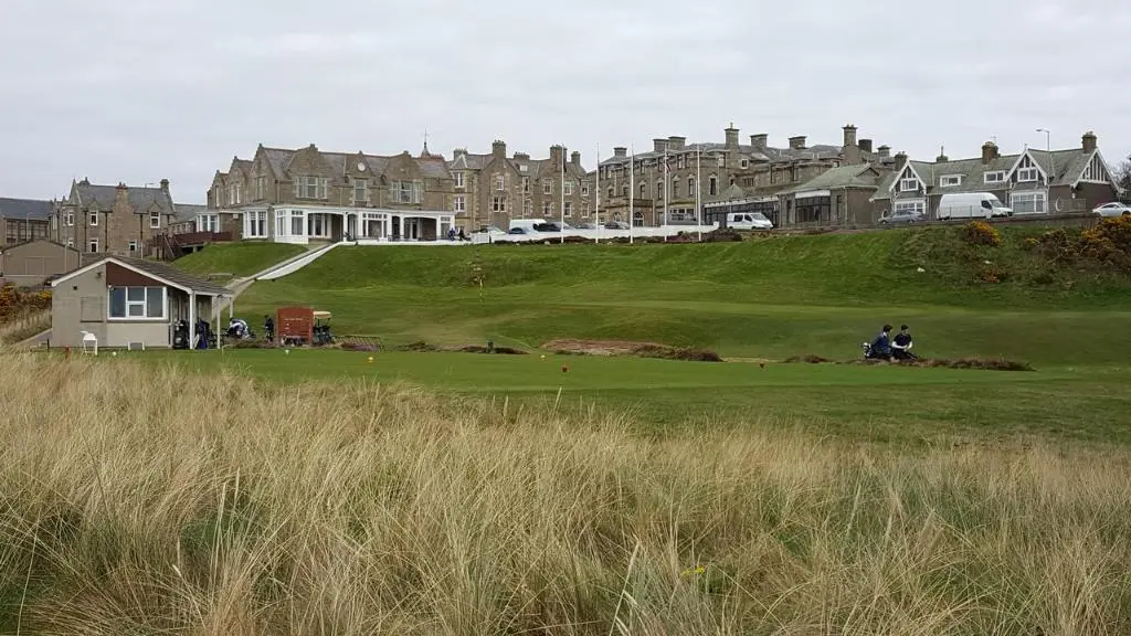 a group of people sitting on a golf green at Tighnabruaich Annex in Lossiemouth