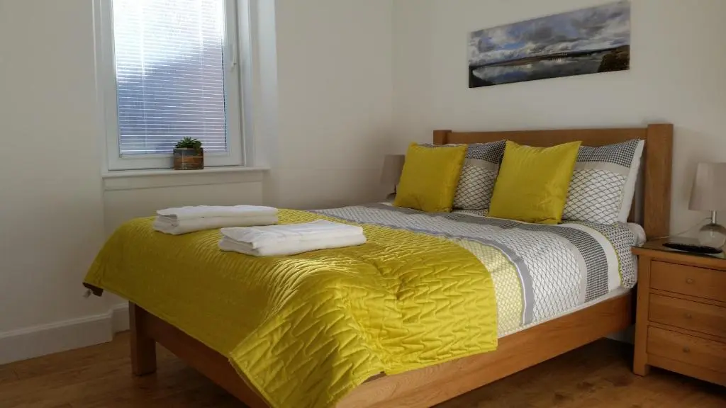 a bedroom with a bed with two towels on it at Tighnabruaich Annex in Lossiemouth