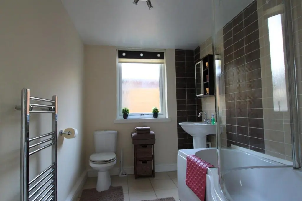 a bathroom with a tub and a toilet and a sink at Nairnia in Nairn