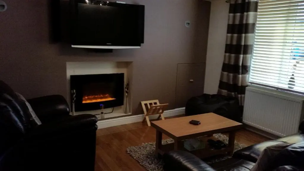 a living room with a fire place in the fireplace at Nairnia in Nairn