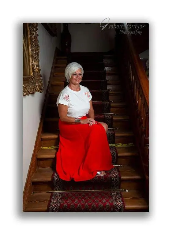 an older woman sitting on the stairs at St Michaels Guest House in Elgin