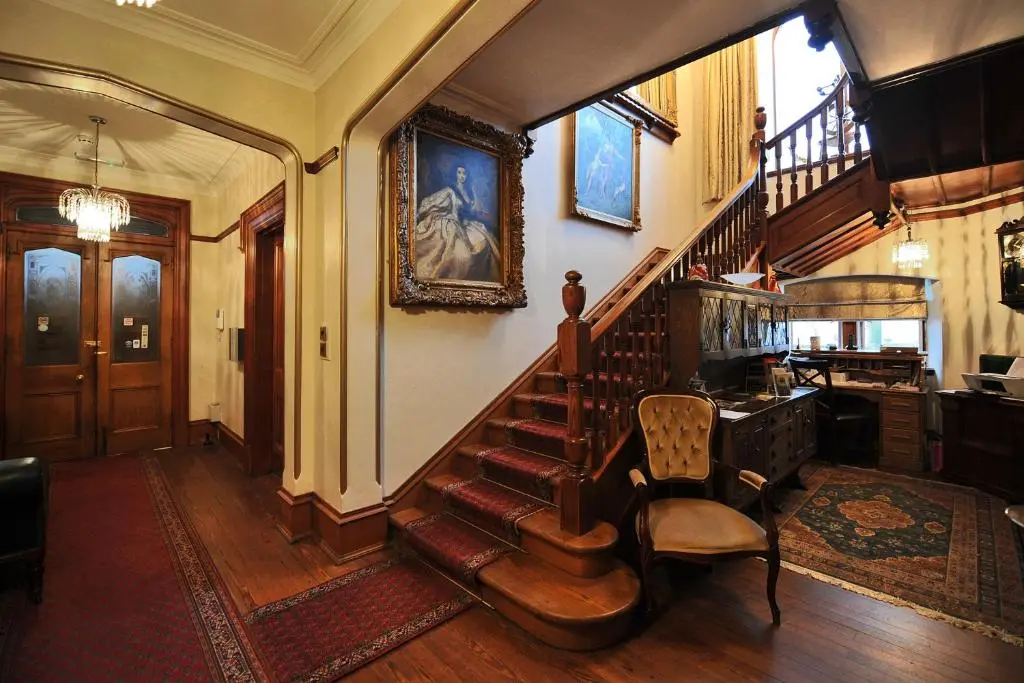 a staircase in a house with a chair and a stair case at St Michaels Guest House in Elgin