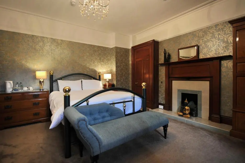 a bedroom with a bed and a fireplace at St Michaels Guest House in Elgin